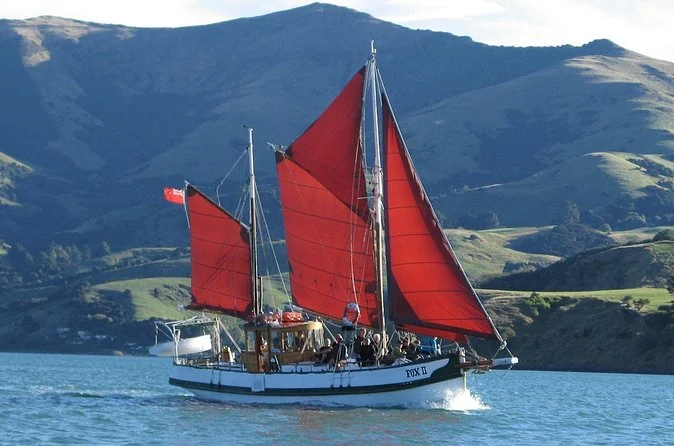 The red-sailed ketch Fox II under sail on Akaroa Harbour